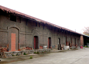 Vista general del estado actual del exterior del muelle cubierto de mercancas n 2 que forma parte de la sede del Museo del Ferrocarril de Madrid. Se observan los muros de fbrica de ladrillo sobre zcalo de mampuesto y cubierta de palastro galvanizado ondulado sobre estructura de hierro.